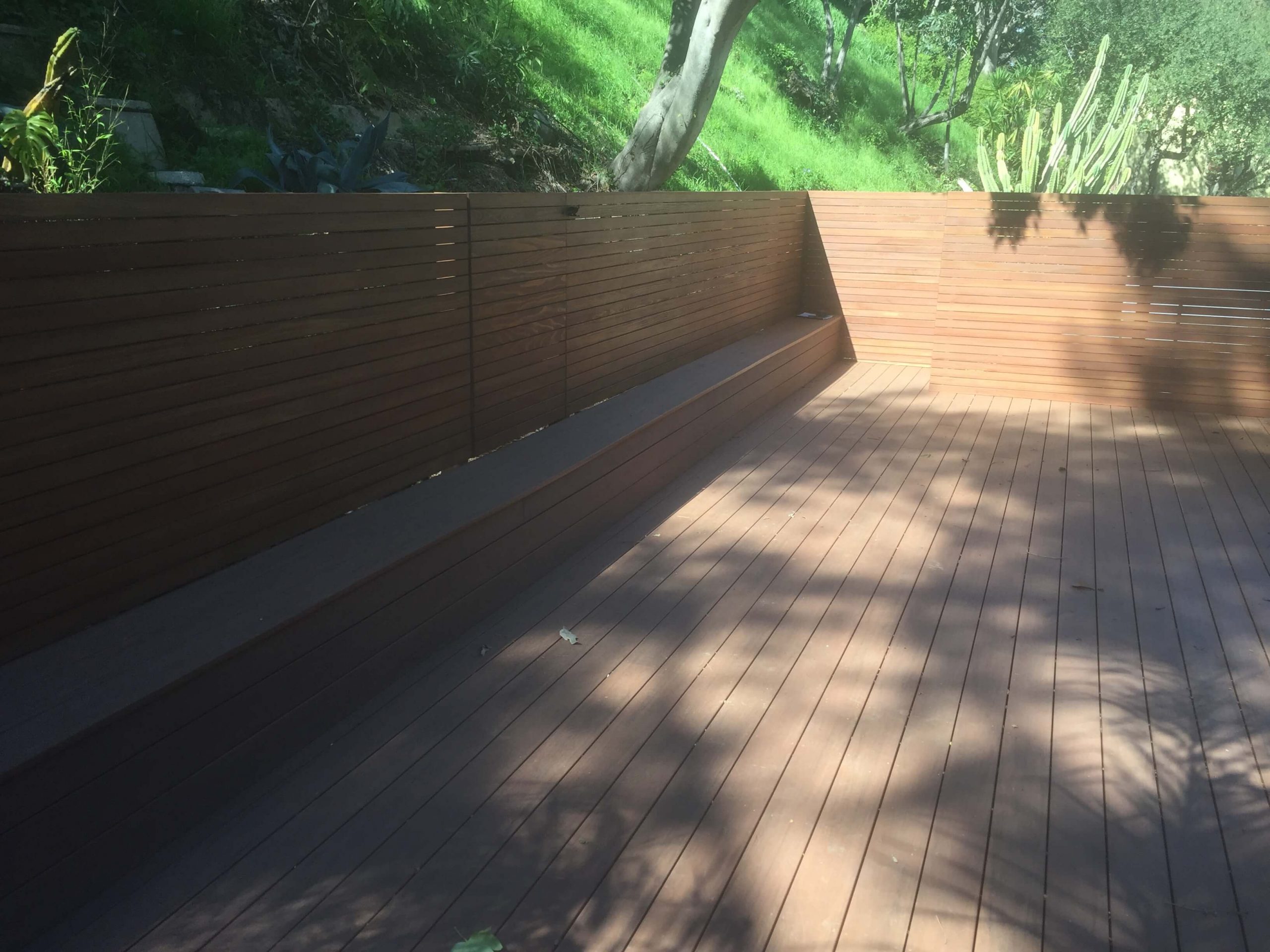 Wooden Deck Surrounded By Wooden Backyard Fence