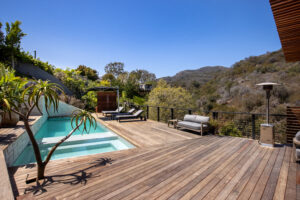 Deck built into hillside featuring built-in planters and natural stone.